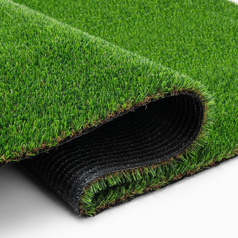 Folded artificial grass showing the green pile, cut edge and black backing.